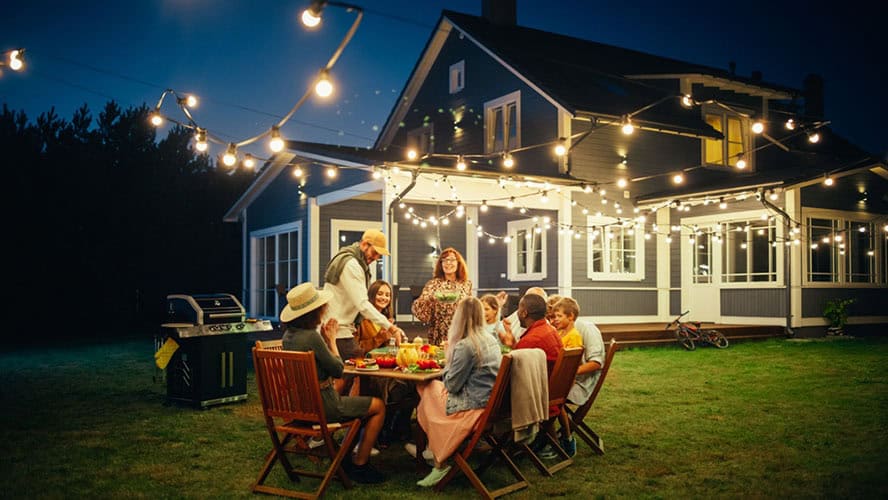 As the sun sets in Suffolk County, NY, a group gathers around a table under twinkling string lights. The two-story house stands proudly in the background while laughter fills the air. Engaging conversations mix with the sizzle from the nearby grill—all in a yard expertly maintained with top-notch tick control.